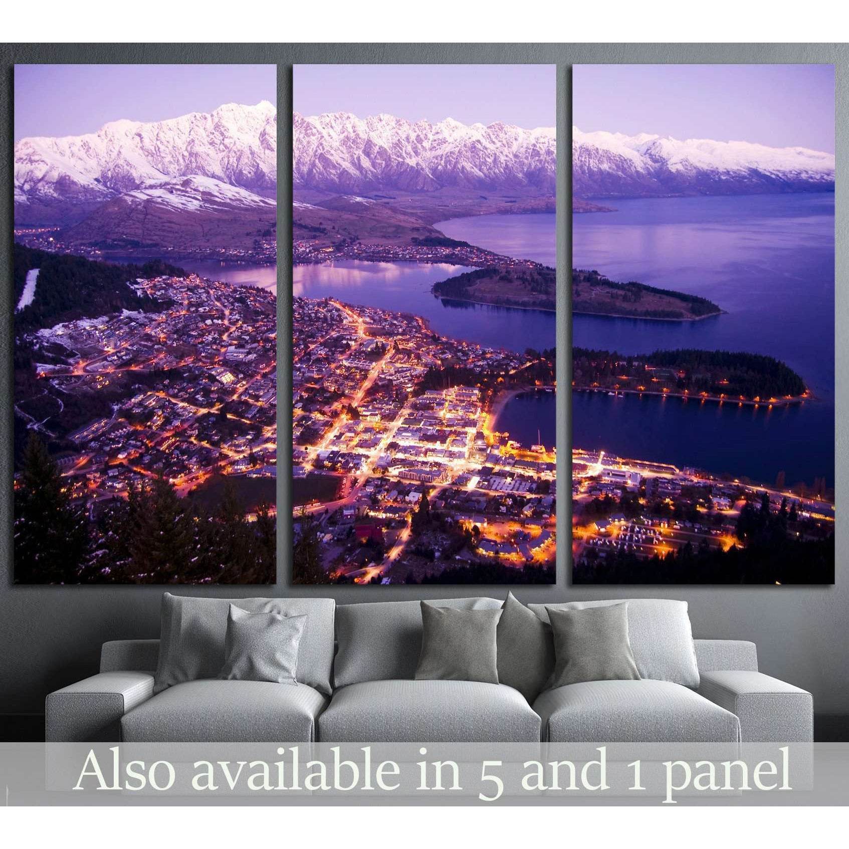 Queenstown night canvas print with city lights, Lake Wakatipu, and snowy mountains above a sofa