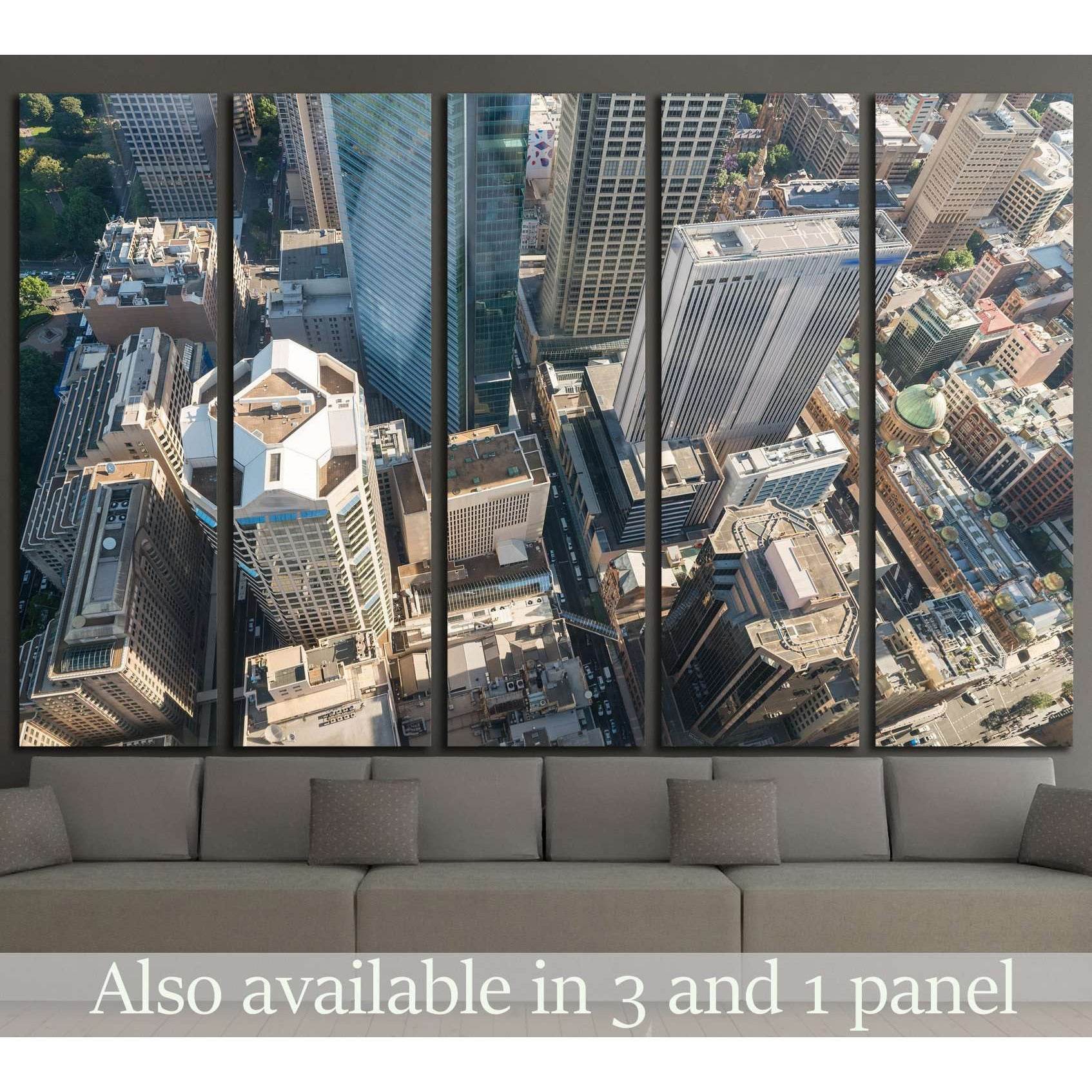 Aerial Sydney skyline canvas print in multi-panel layout above sofa in a modern living room