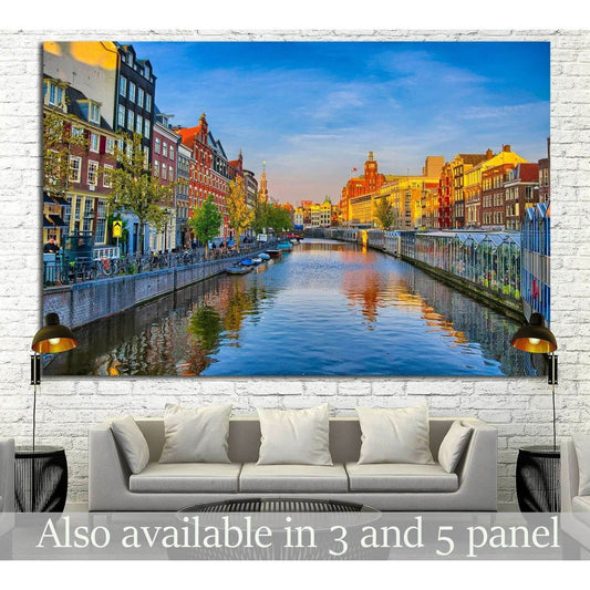 Amsterdam canal canvas print with colorful Dutch houses, blue sky, and water reflections above a sofa