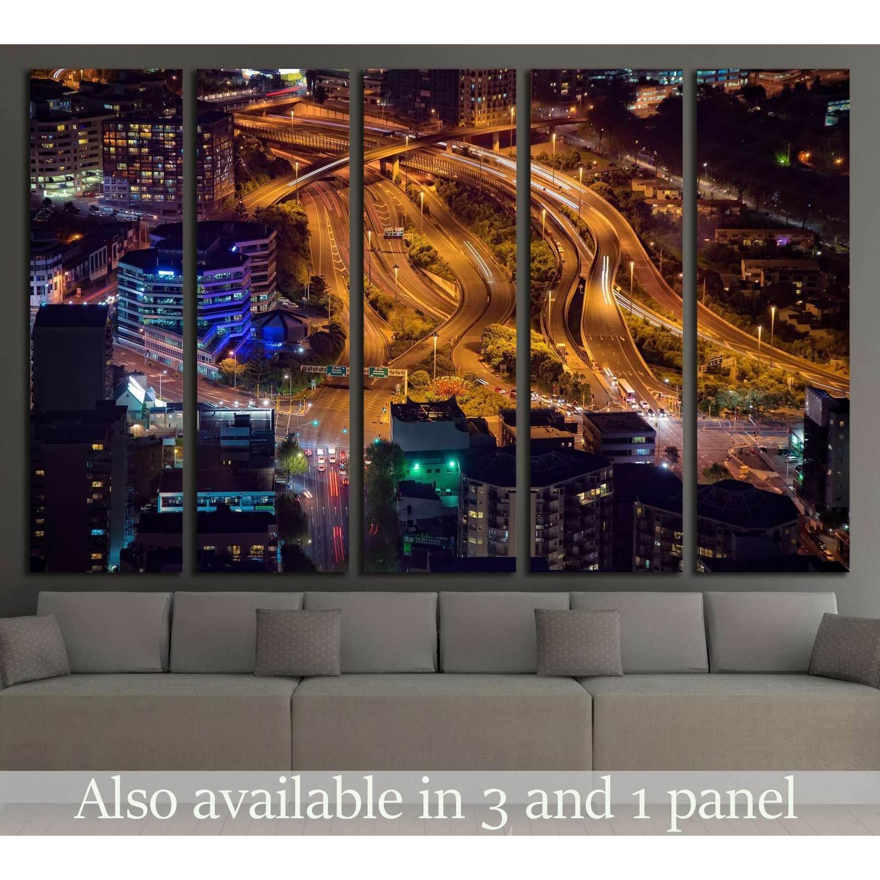 Auckland night cityscape canvas print with golden highway light trails, displayed above a sofa