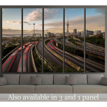 Auckland Sky Tower canvas print with motorway light trails at dusk above a sofa in a modern living room