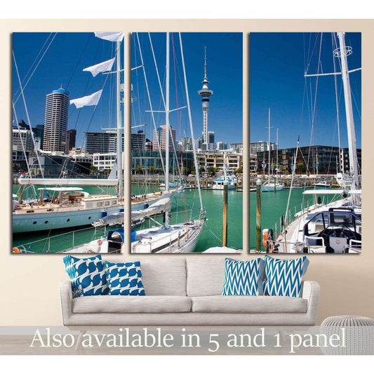 Auckland marina canvas print with sailboats, turquoise water, and Sky Tower above a sofa