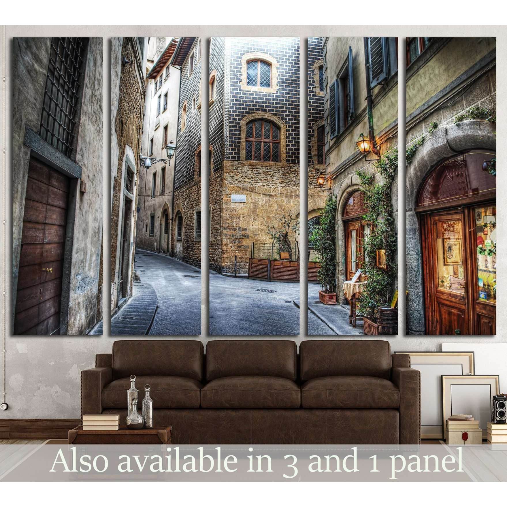 Florence alley canvas print showing a narrow Tuscan street above a sofa in a rustic living room