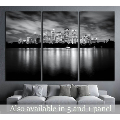 Black and white Sydney skyline triptych canvas print above a sofa with night reflections on the water