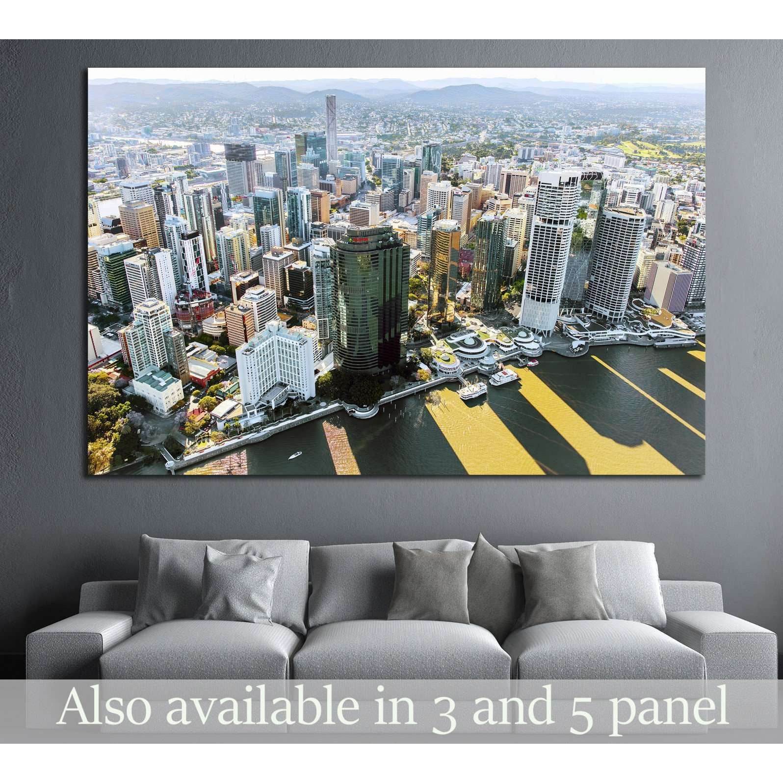Brisbane skyline aerial canvas print above sofa in a modern living room with riverfront city view