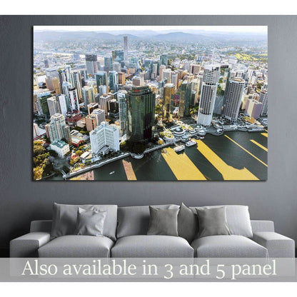 Brisbane skyline aerial canvas print above sofa in a modern living room with riverfront city view