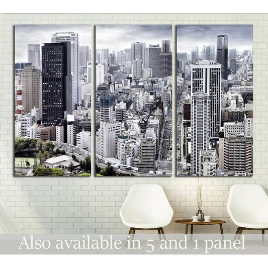 Monochrome city skyline triptych canvas print with dense skyscrapers above chairs in a modern room