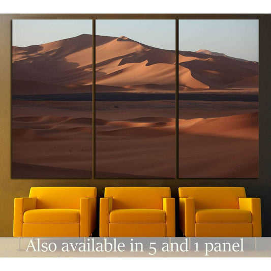 Triptych Sahara dunes canvas print hung above three mustard chairs in a modern waiting area