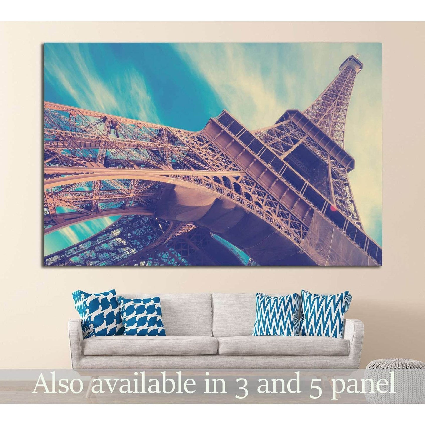 Low-angle Eiffel Tower canvas print in pastel teal sky above sofa in modern living room