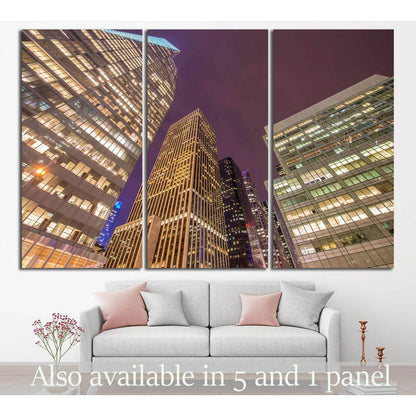 NYC skyscrapers canvas print in a three-panel night city view above a sofa
