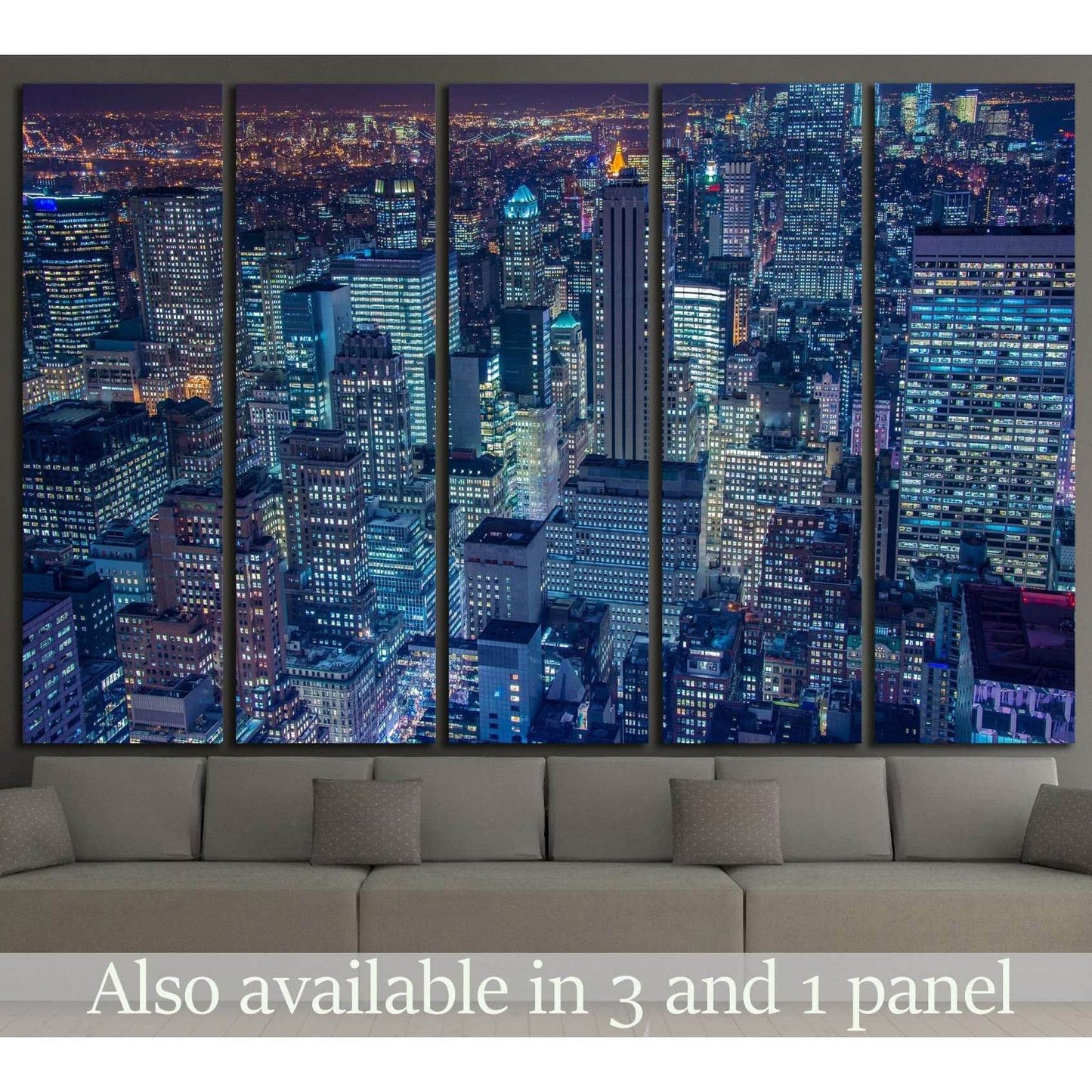 New York night skyline canvas print in five panels above a sofa with blue-lit skyscrapers