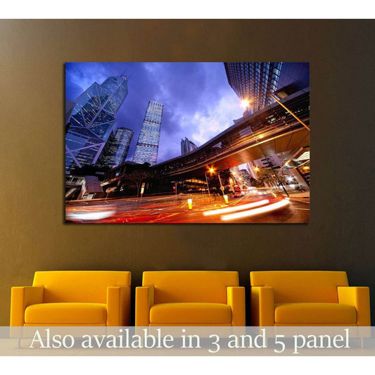 City night light trails canvas print with skyscrapers and fast traffic, hung above chairs in a modern office lobby