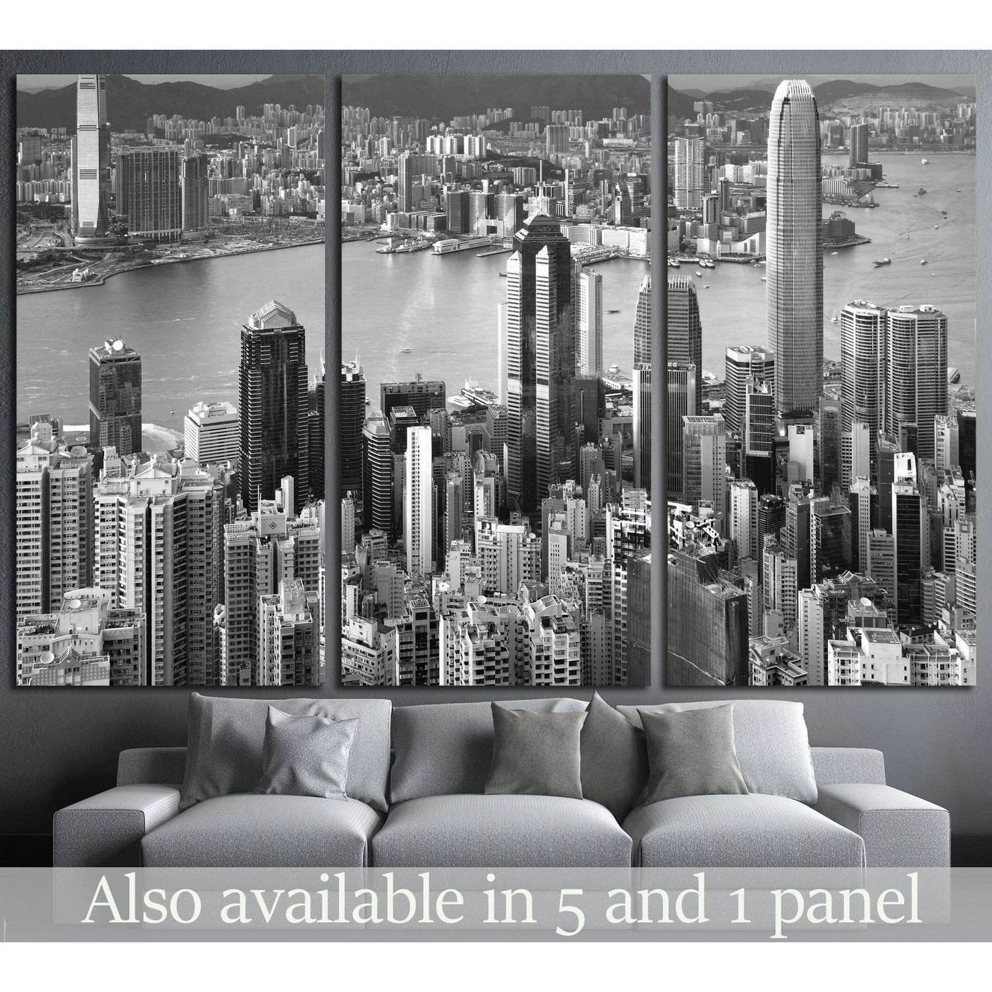 Black and white Hong Kong skyline canvas print in triptych layout above a grey sofa