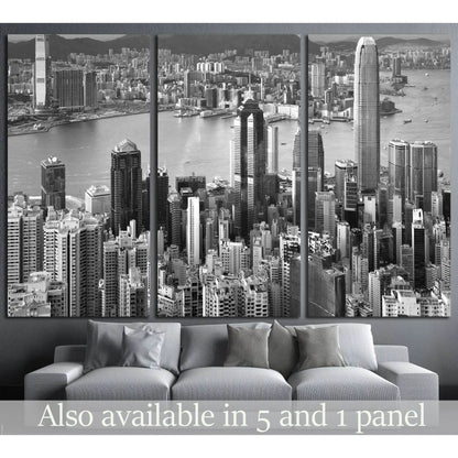 Black and white Hong Kong skyline canvas print in triptych layout above a grey sofa