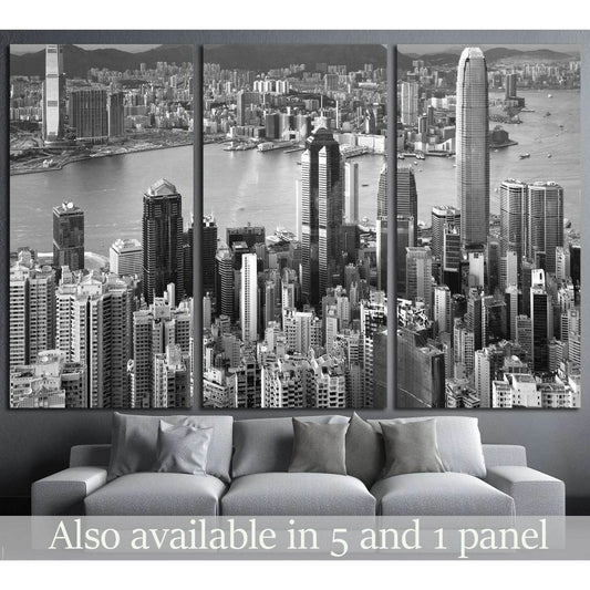 Black and white Hong Kong skyline canvas print in triptych layout above a grey sofa