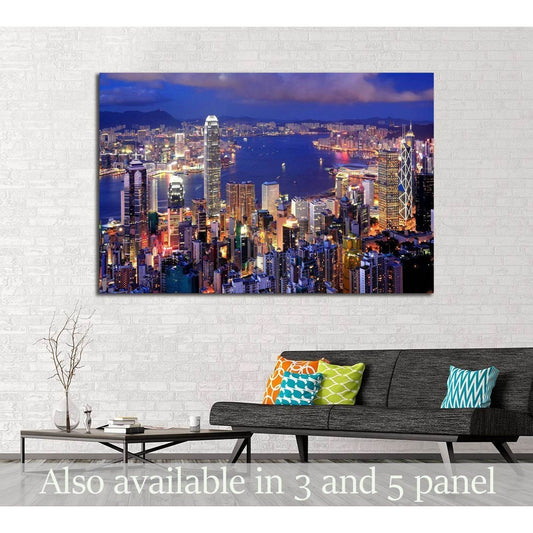 Hong Kong night skyline canvas print above sofa in modern living room with blue harbor lights