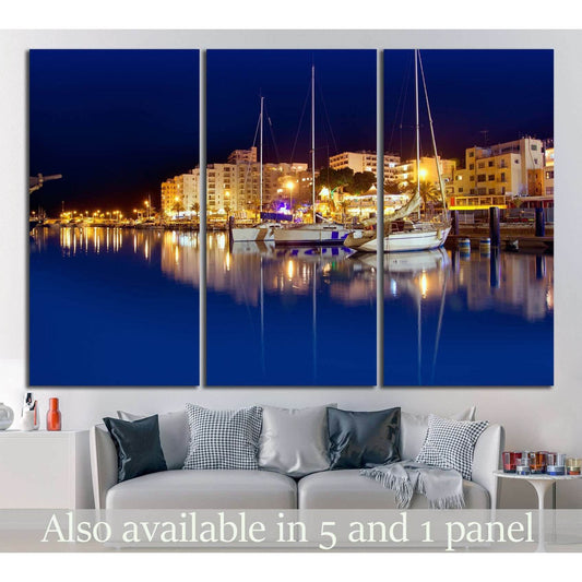 Ibiza harbor night canvas print with sailboats and glowing marina reflections above a sofa