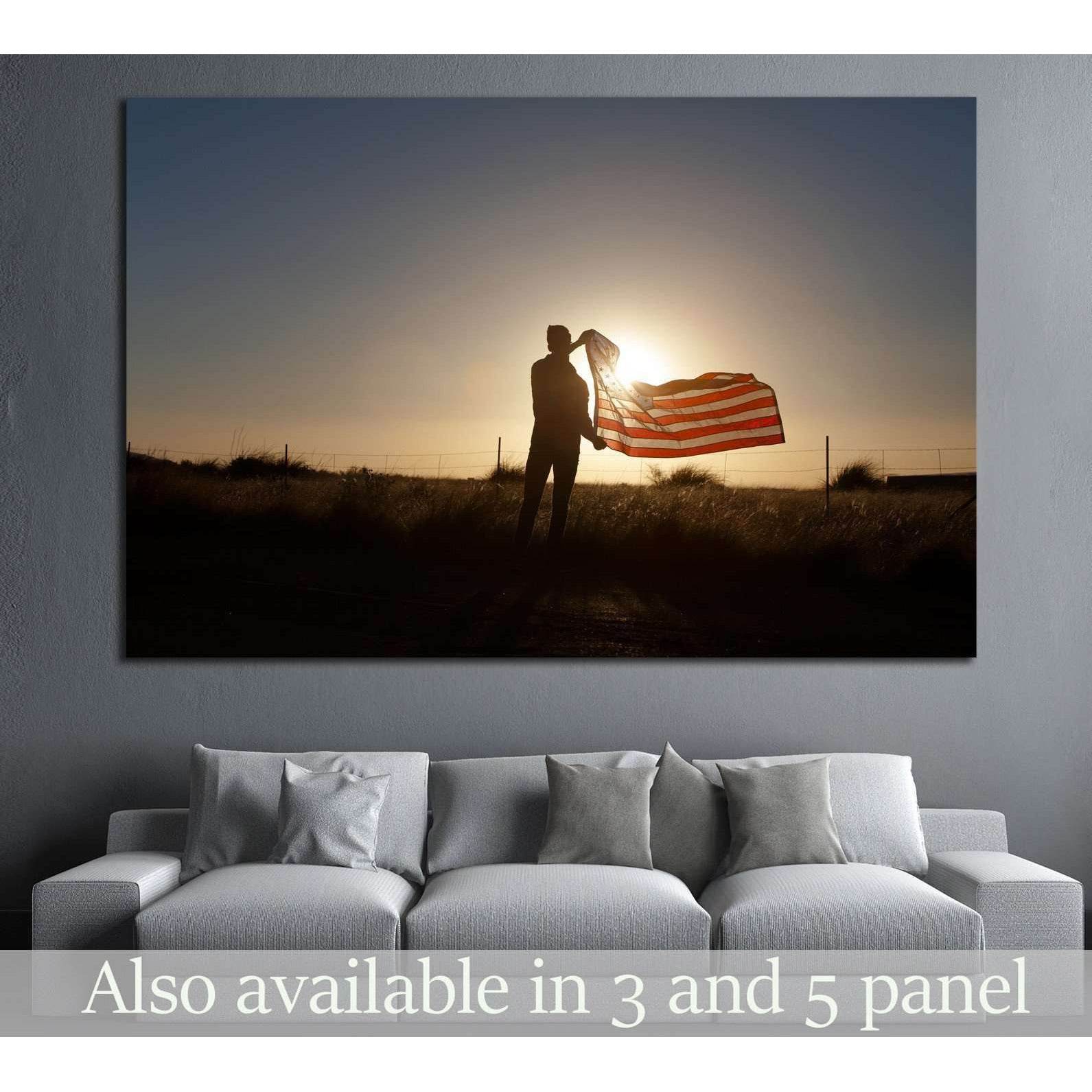 Silhouette holding American flag at sunset canvas print above sofa in a modern living room