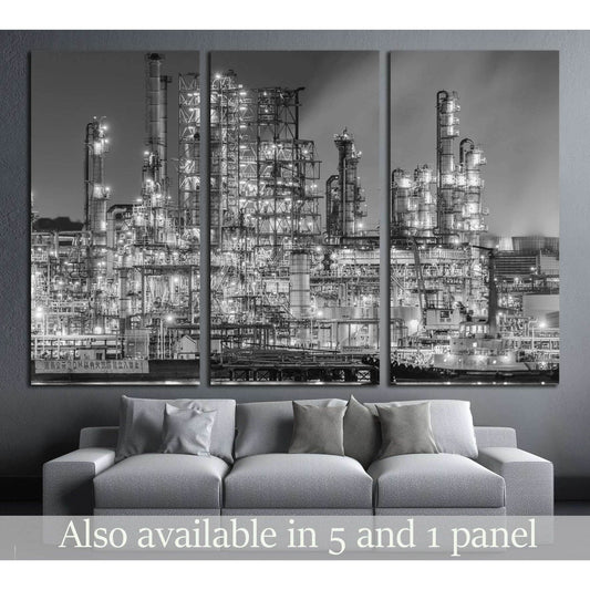 Black and white refinery factory canvas print at night displayed above a sofa in a modern living room
