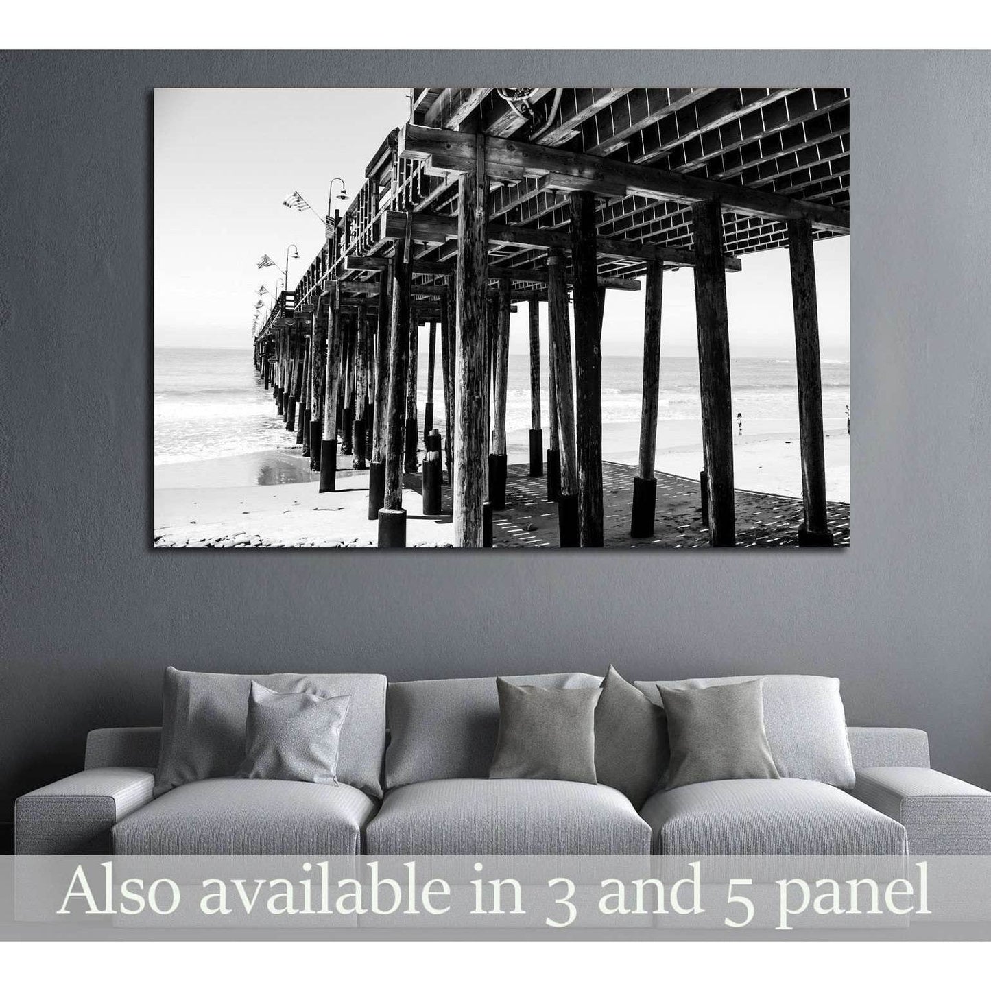Black and white pier canvas print above a sofa in a modern coastal living room