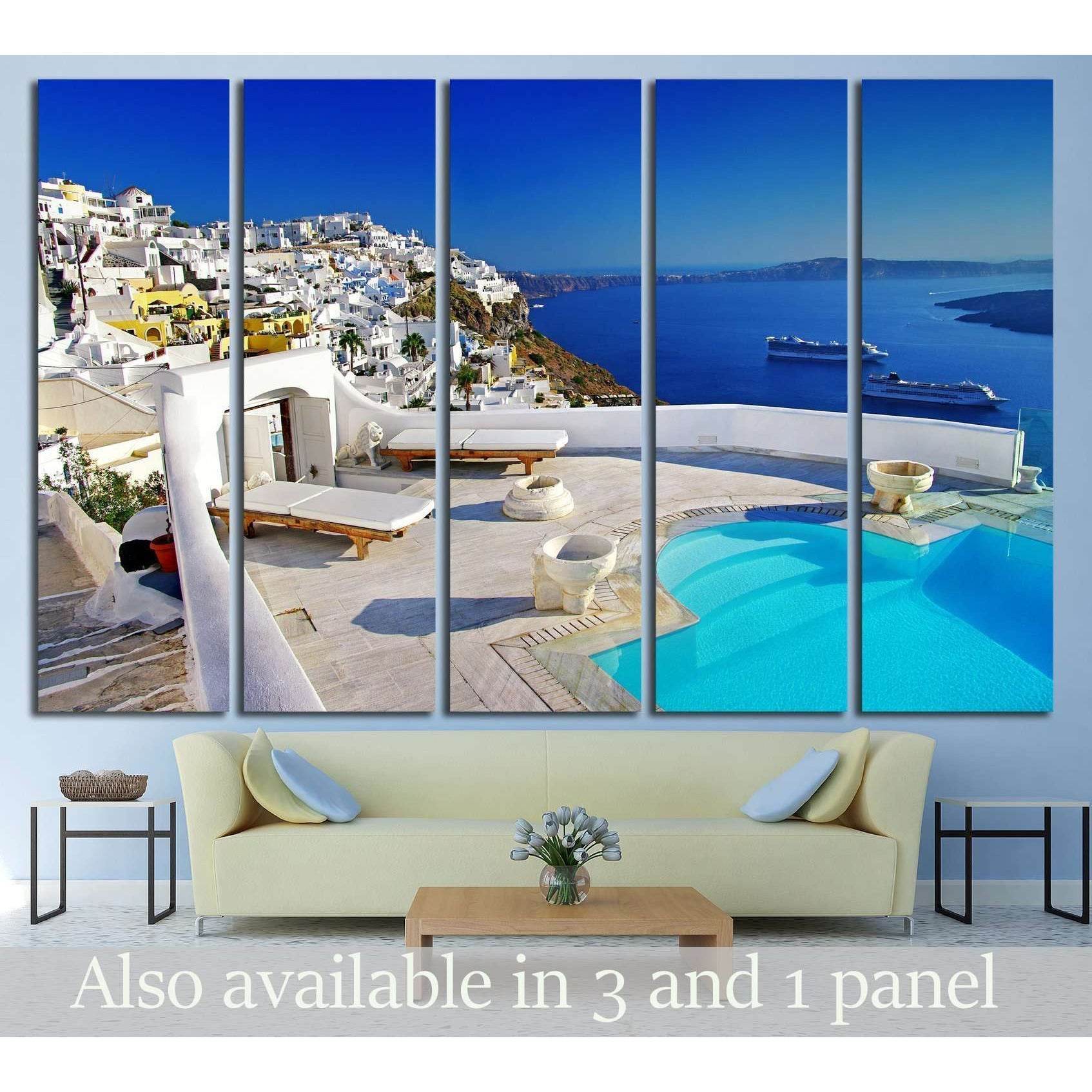 Santorini cliffside pool canvas print with white villas and blue caldera, displayed above a sofa