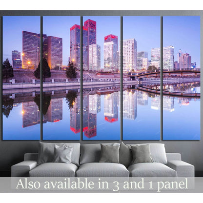 Beijing skyline canvas print with sunset-lit skyscrapers and water reflection above a grey sofa
