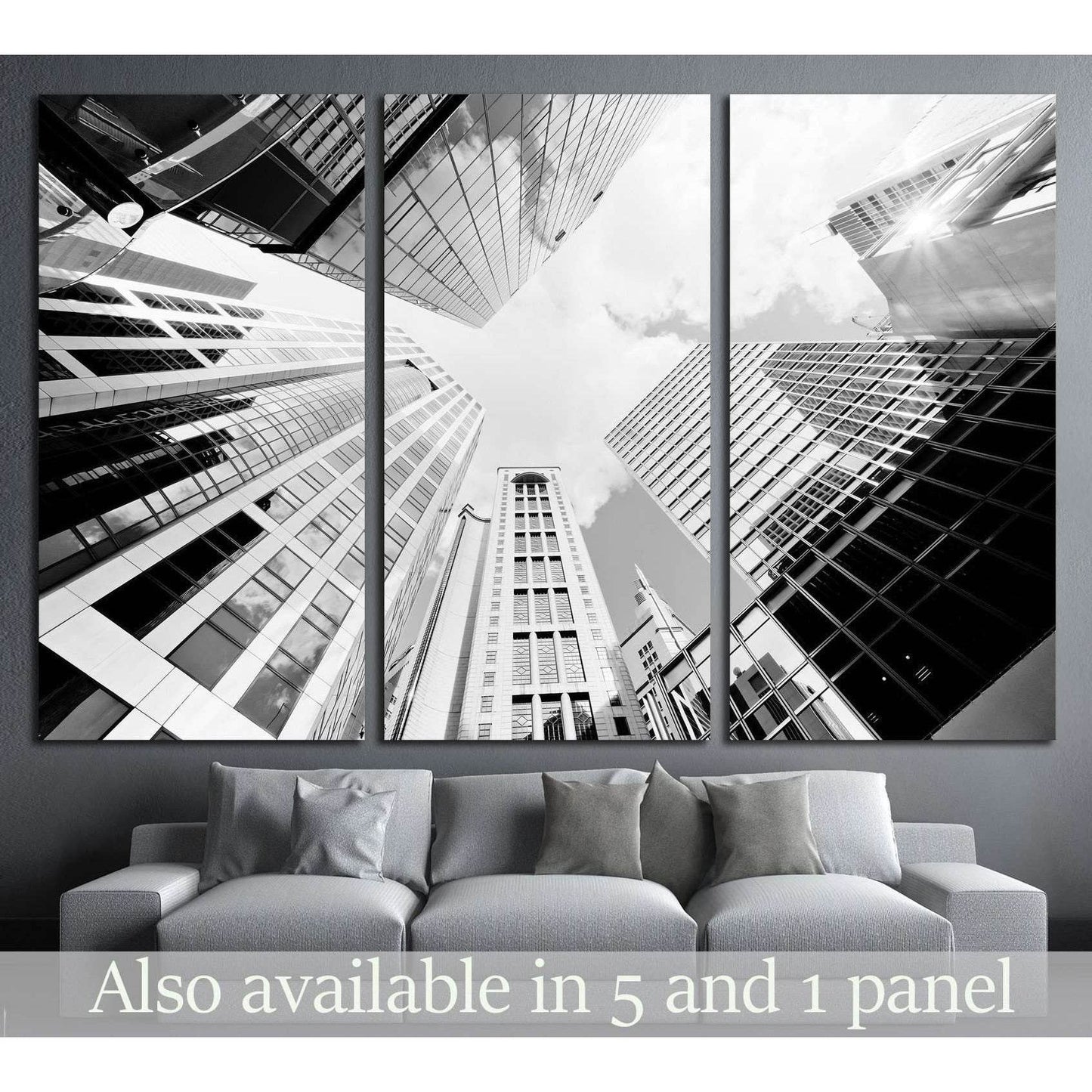 Black and white skyscraper triptych canvas print above sofa in a modern gray living room