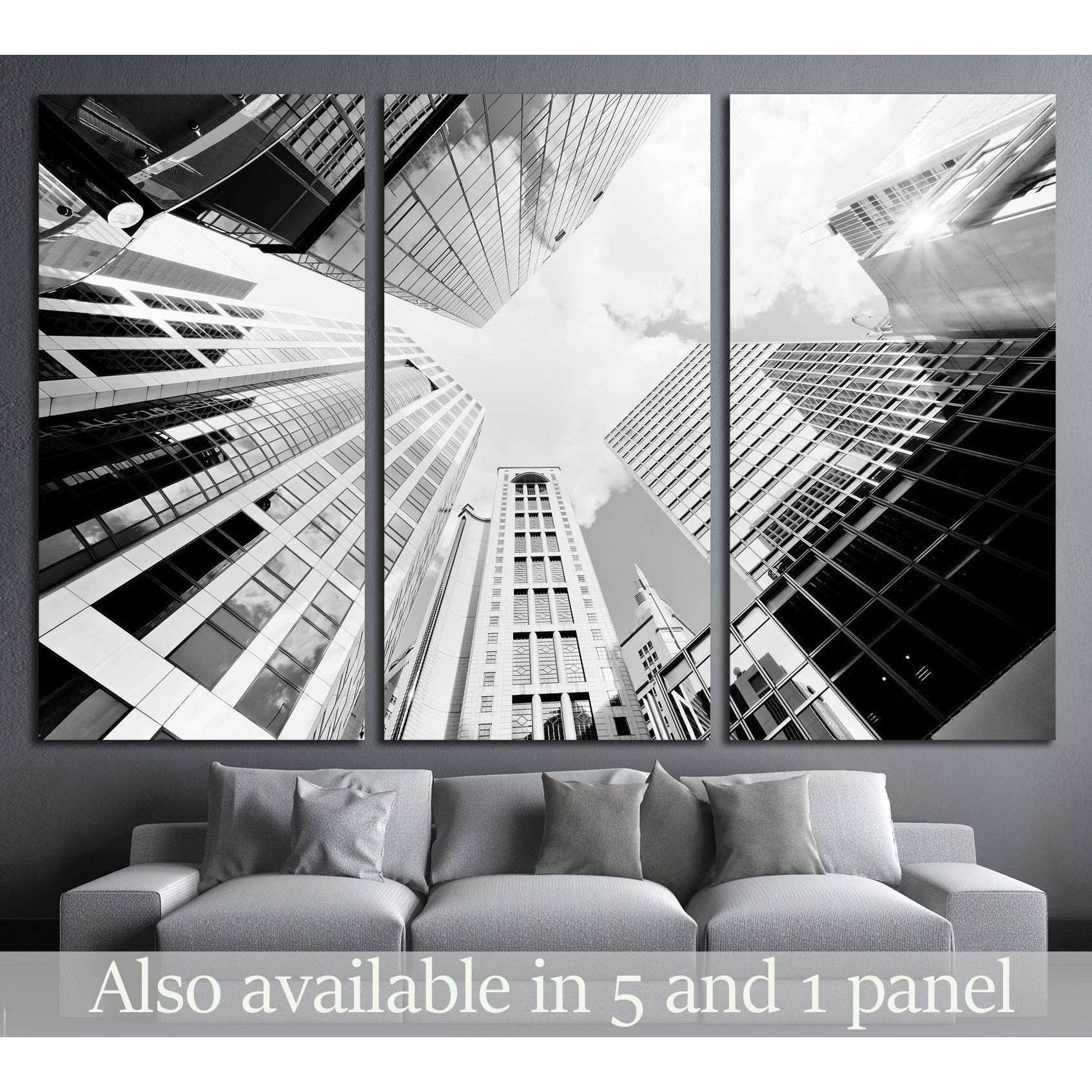 Black and white skyscraper triptych canvas print above sofa in a modern gray living room