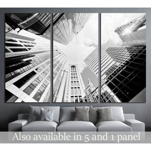 Black and white skyscraper triptych canvas print above sofa in a modern gray living room