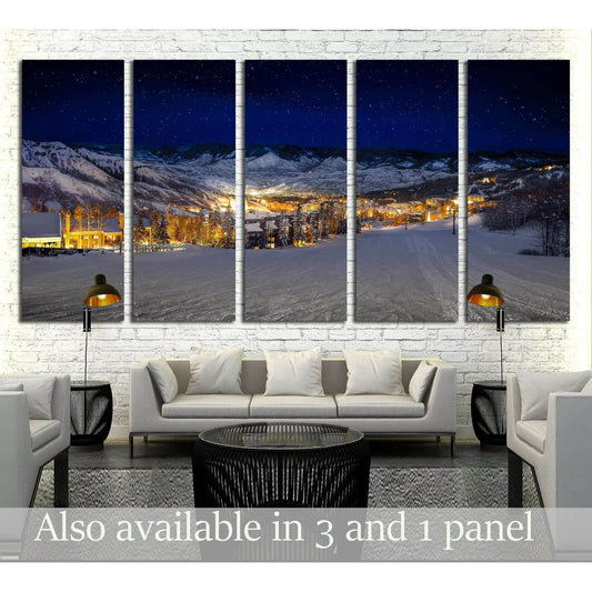 Starlit Ski Village Canvas Print for Cozy Winter DecorThis canvas print features a night-time view of a snow-covered ski village, with glowing lights that offer a warm contrast to the cool blue hues of the evening. The clear starry sky adds a touch of mag