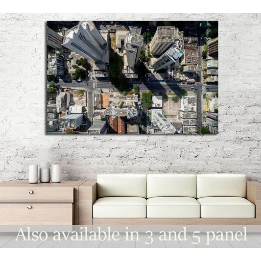 Aerial cityscape canvas print with top-down skyscrapers and streets hung above a sofa in a modern living room