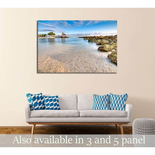 Nassau beach canvas print with turquoise water and rocky shore above sofa in coastal living room
