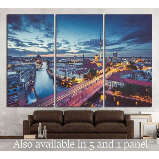 Berlin skyline triptych canvas print with Spree River and TV Tower at twilight above a brown sofa