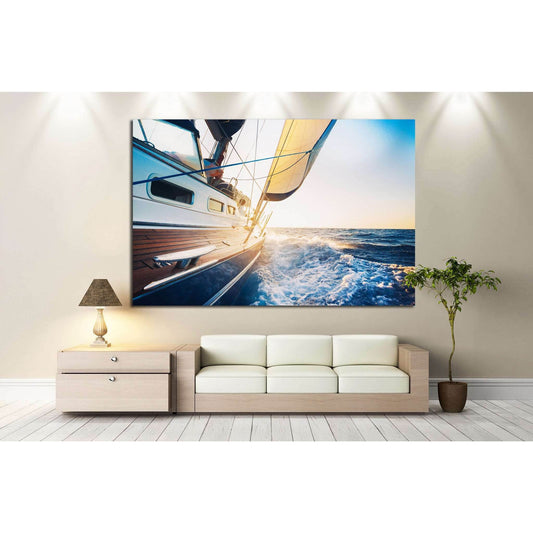 Sailboat canvas print of a yacht cutting through blue waves at sunset above a sofa in a modern living room